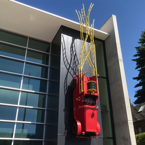 Engine 32 1/2 large-scale public art sculpture in Seattle featuring a fire truck form with extended ladders integrated into fire station architecture